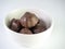 White ceramic bowl full of chocolate cake pop balls with chocola