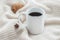 White ceramic cup of coffee without cream with cosy blanket, cookie and star anice