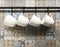 White ceramic cups hanging on hook in front of art pattern tile