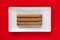 White ceramic dish with luxury Cuban cigars on over red background