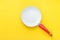 White Ceramic Frying Pan with Red Handle on Bright Yellow Background. Creative Styled Image. Breakfast Energy Kitchen Utensils