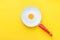 White Ceramic Frying Pan with Red Handle on Bright Yellow Background. Yolk in the Middle. Sunny Side Up Fried Eggs Collage.