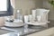 White ceramic set and stainless kitchen utensils on the counter