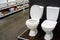 White ceramic toilets are available in the store. Showcase with products in the retail network. Copy space