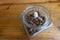 A white ceramic wake up in coffee beans from a glass jar , table background. Close up. wake up in the morning