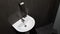 White ceramic washbasin with chrome faucet in the toilet with gray tile