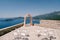 White chairs stand in front of the wedding arch on the observation deck above the sea