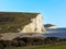 The white chalk cliffs of the Seven Sisters rise majestically above the sea in Sussex, UK