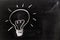 White chalk handdrawing in light bulb shape on blackboard background Concept for new idea