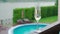 White champagne or prosecco glass against poolside at luxury resort hotel during vacation Close-up. Refreshing alcohol drink.
