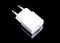 White charger adapter on black background
