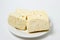 White cheese on a white background. Homemade white cheese on a plate.