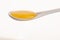 White cheramic spoon filled with sweet golden honey.