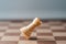 White chess castle falling on chess board concept of failing
