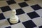White chess pawn alone on black square on chess board