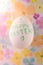 White chicken egg with a green inscription Happy Easter
