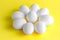 White chicken eggs on a colored yellow background placed in a circle like camomile. Concept of healthy natural farm products,