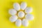 White chicken eggs on a colored yellow background placed like camomile. Concept of healthy natural farm products, top view