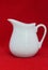 White china jug on red cloth