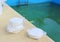 White chlorine tablet in the hand of maintenance personnel for disinfection of swimming pools. Water purification. Green water wit