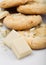 White chocolate biscuit cookies with chocolate blocks and curls on white background