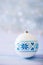 White Christmas ball with blue winter Ukrainian ornament on light bokeh background