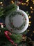 White Christmas ball with mockup friendly empty space hanging on Christmas tree branch