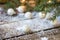 White Christmas balls, evergreens and snow on wooden underground