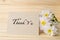 White chrysanthemum flowers with thank you card on wooden table