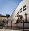 White church with crucifix in front and metal fence on a sunny day