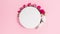 White circle background is decorated natural flowers buds. Pink background. Template for text or design.