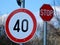 White circular speed limit road and traffic sign and STOP sign beyond