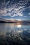 White Cirrus Cloud in a Blue sky with Water Reflections