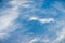 White cirrus clouds on a blue sky background