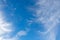 White cirrus clouds in the blue sky on a clear day in the summer. Used as a background image