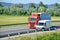 White CitroÃ«n van overtakes red MAN truck on slovak D1 highway in countryside.