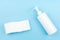 White Cleansing spray bottle and cotton pad on blue background