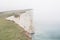 White cliff and lighthouse in mist