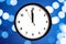 The white clock shows five seconds to midnight, on the bokeh background. Countdown to the new year