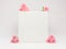 White closed box decorated with fresh flowers roses on a white background. Beautiful mockup concept for your text, logo, brand.