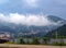 A white cloud descended on the village at the foot of a forested mountain