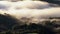 White clouds above mountain forest, mysterious natural landscape, panning down