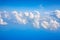 White clouds on blue sky background close up, cumulus clouds high in azure skies, beautiful aerial cloudscape view from above