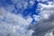 White clouds in the blue sky. Natural summer background. Thickening of rain clouds in one place