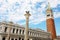 White clouds in the blue sky on St. Mark square with bell tower and lion statue in Venice, Italy