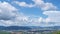 White clouds move in the clear blue sky over buildings in phuket city. Motion time lapse white clouds swim and change shape. Puffy