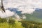 white clouds over wooded mountains with country roads, lake, aerial ropeway