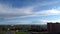 White clouds running over city, summer cloudscape. Timelaps.