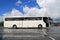 White Coach Bus Waits for Passengers on Foggy Rainy Morning
