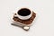 White coffee cup with coffee, plate with coffee beans and black teaspoon with sugar